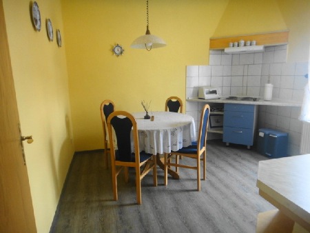 Küche der Erdgeschosswohnung mit Esstisch und Küchenzeile