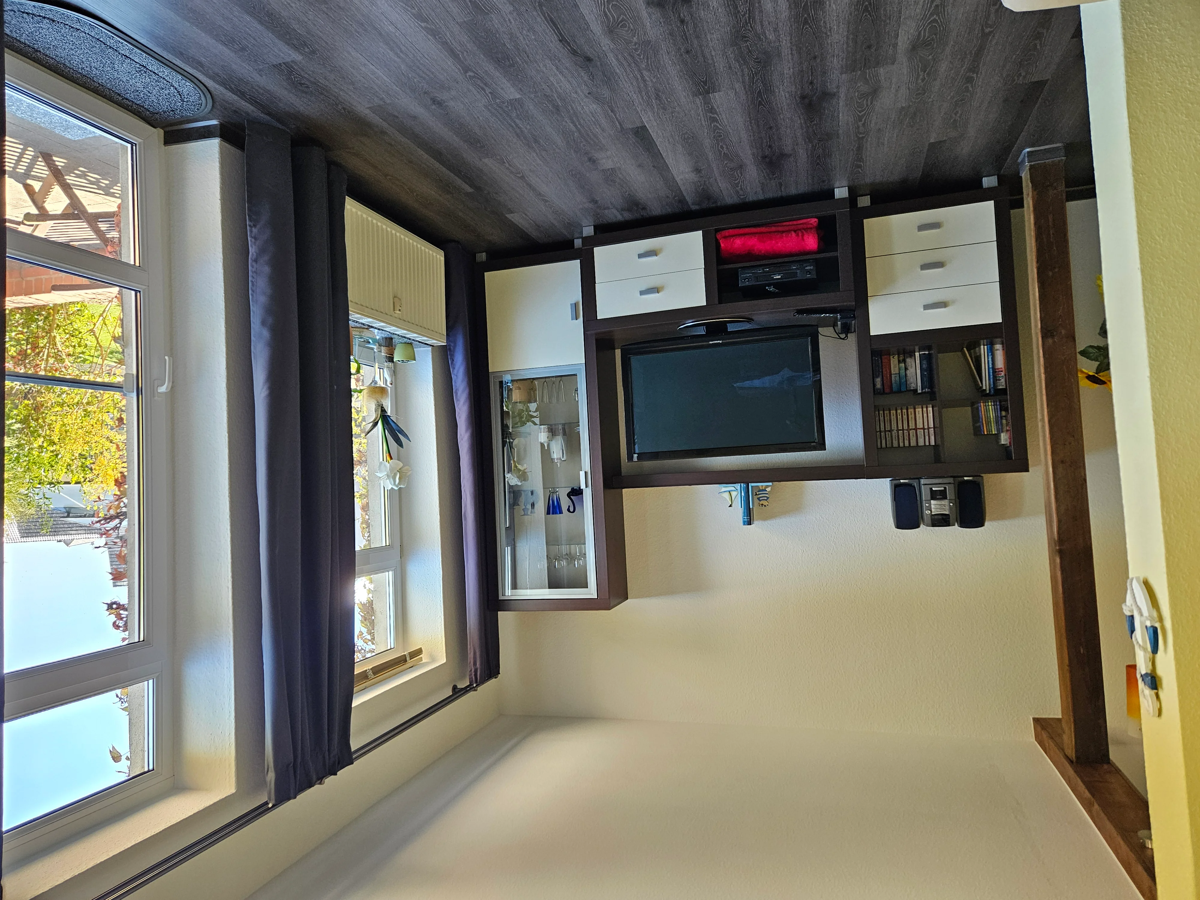Wohnzimmer der Erdgeschosswohnung mit Holzbalken und Sofa