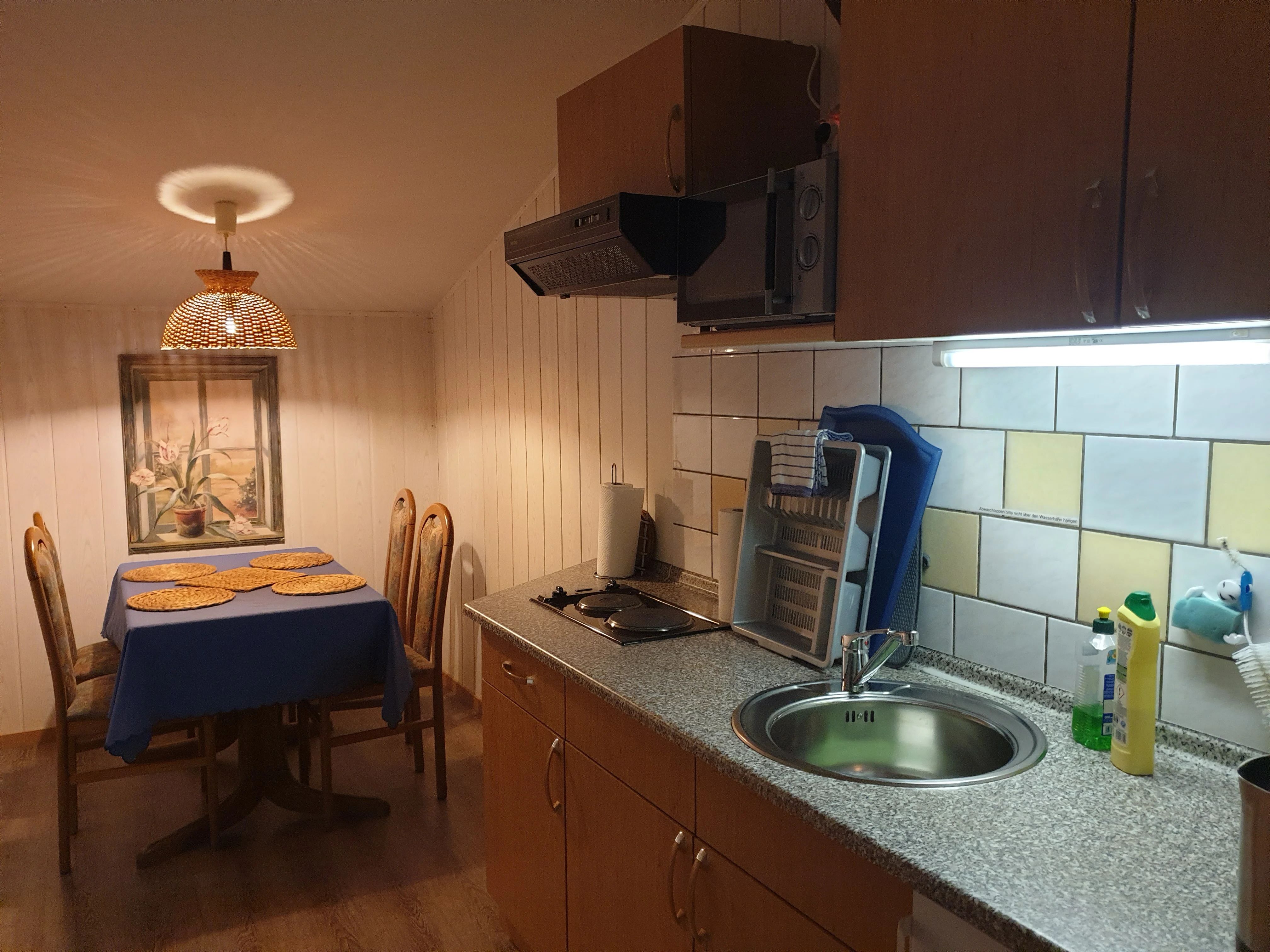Innenküche der Obergeschosswohnung mit Tisch, vier Stühlen und vollständiger Ausstattung