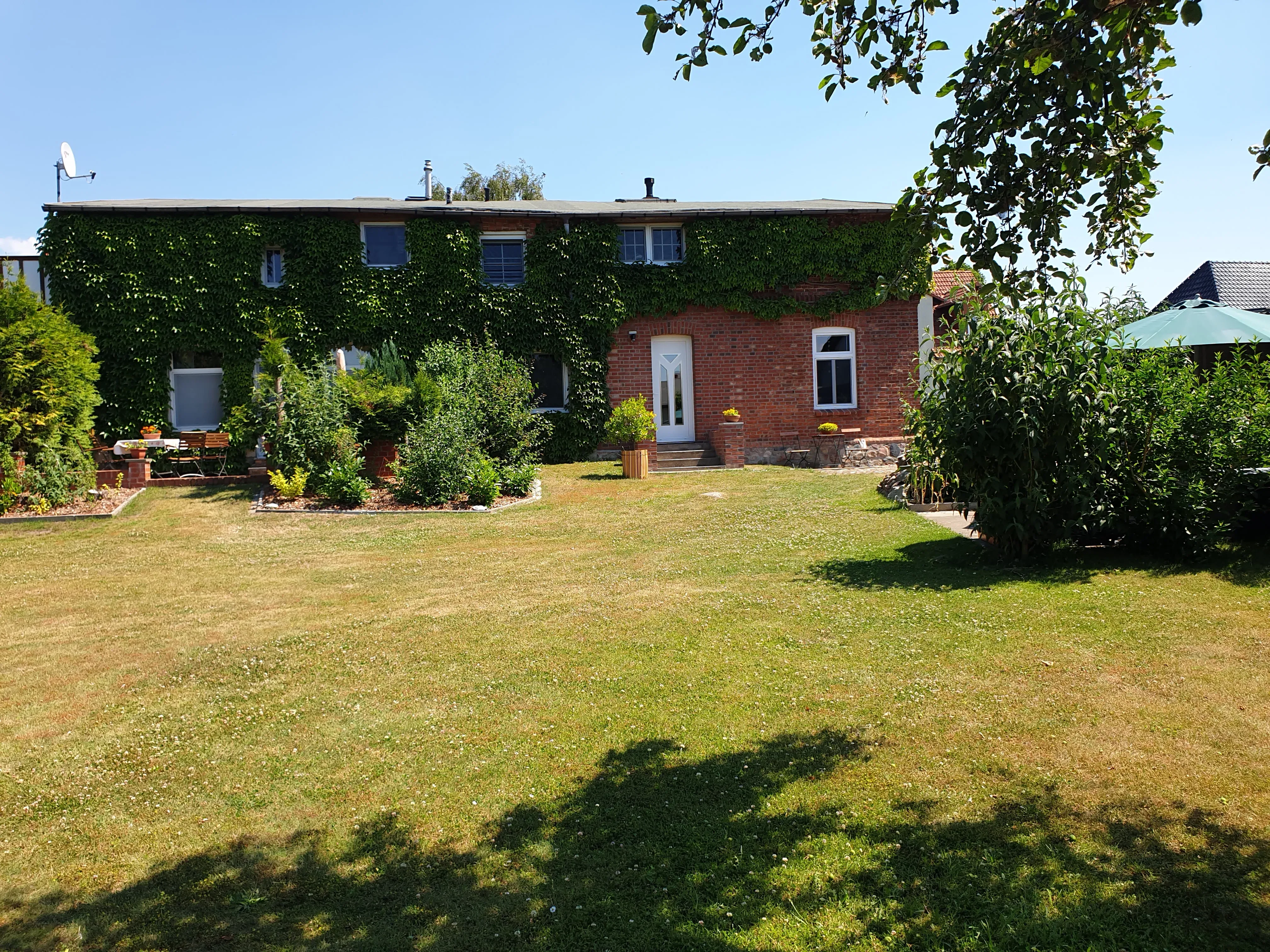 Terrasse mit Strandkorb, Tisch und Stühlen am Hof