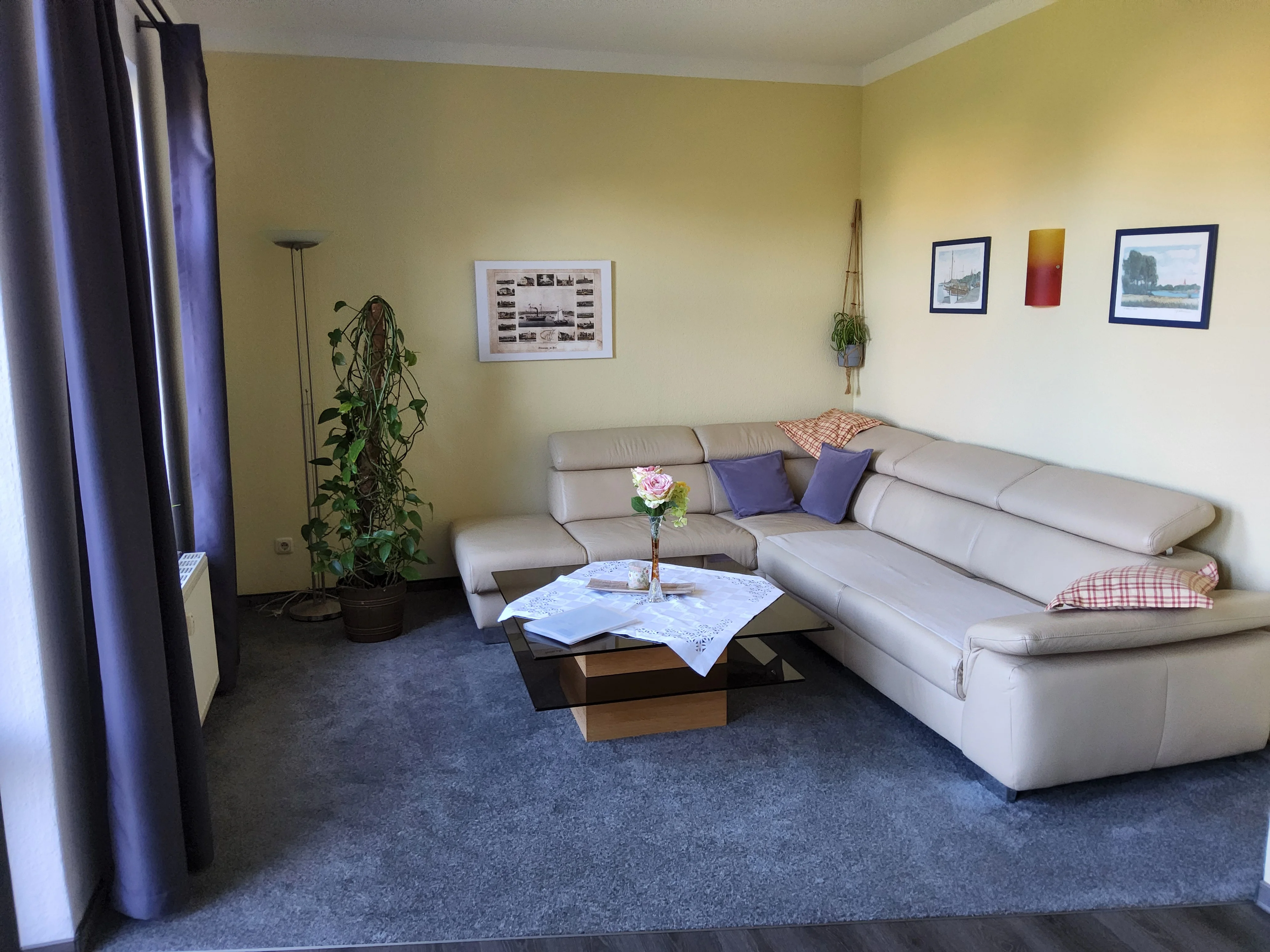 Wohnzimmer der Erdgeschosswohnung — zweite Ansicht mit Sofa und Holzbalken