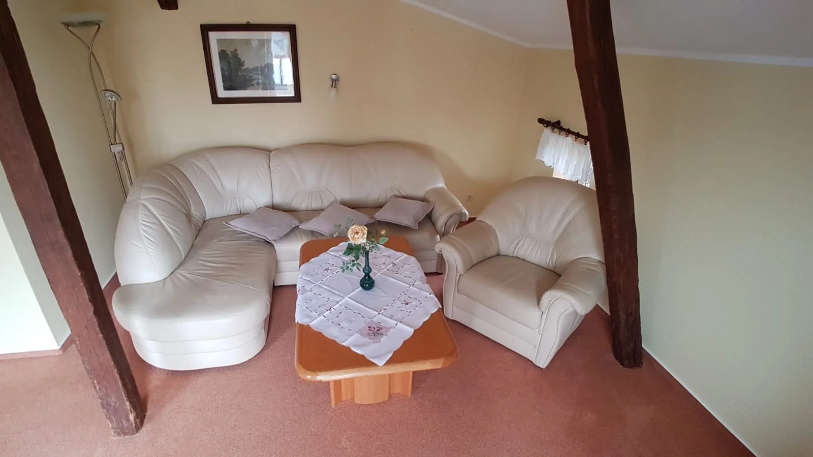Wohnzimmer der Obergeschosswohnung mit hellem Holz und alten Balken